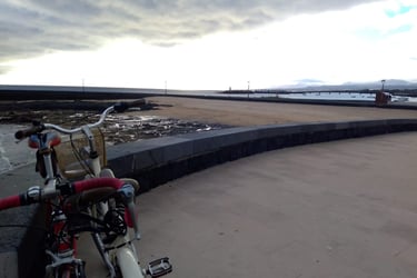 a bicycle parked on a concrete wall next to a body of water