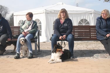 Kurze Pause. Zwei Kunden sitzen auf einer Bank am Südstrand mit ihren Hunden