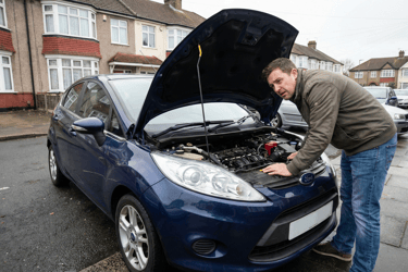 UK driver checking car engine on a residential street to improve fuel economy