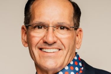 a man in a suit and tie with a polka dot shirt