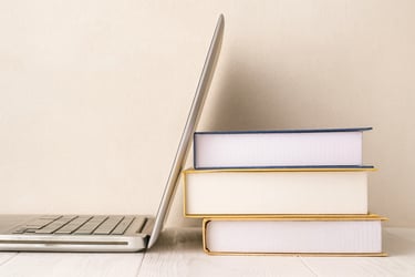 A laptop leaning against some books