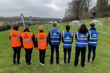 a group of people in safety vests standing in a field