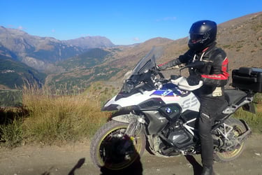 a man in a black jacket and helmet on a motorcycle