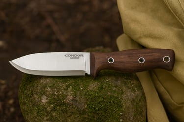 Condor Bushlore fixed blade survival knife with wood handle on mossy rock