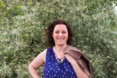 Natanya in a blue top with a brown jacket