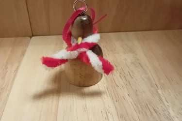 Penguin hanging Christmas decoration in dark wood with light wood tummy and pipecleaner scarf