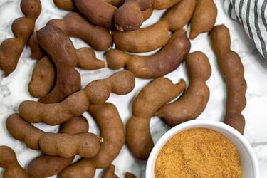a bowl of tamarind powder and a bunch of tamarind