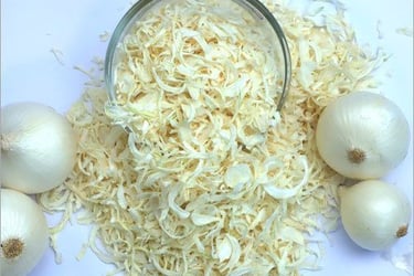 a bowl of dehydrated onions with raw onions on a table