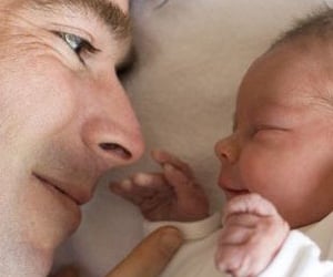 visage d'un père face au visage de son bébé
