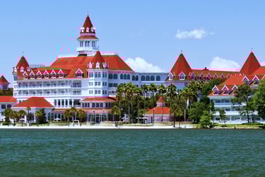 a large white building with a red roof and a tower