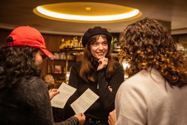 Young woman smiling supportive at two other women, during public speaking exercise.