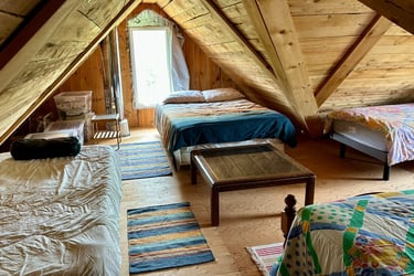 Lit dortoir dans la mezzanine d'une cabane en bois.
