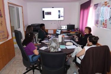 A diverse group of women sitting around a conference table during a collaborative business workshop or meeting.