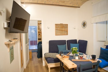 Modern Studio Paolina Rome apartment living area with sofas, dining table, Smart TV, WI-FI