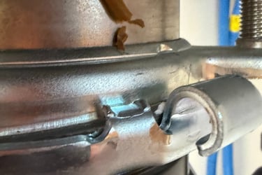 Close-up of a metal garbage disposal mounting assembly showing a secure locking ring under a kitchen sink.