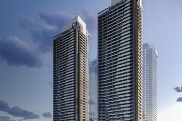 Modern luxury high-rise residential towers with glass balconies and architectural rooftops under a blue sky.