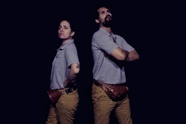 Imagem do espetáculo Não deixe que eles percebam, com os atores, Karina Scott e Daniel Prata, de costa um para o outro.