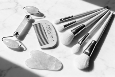 A curated GWP set of beauty tools: facial roller, Gua Sha, and comb.