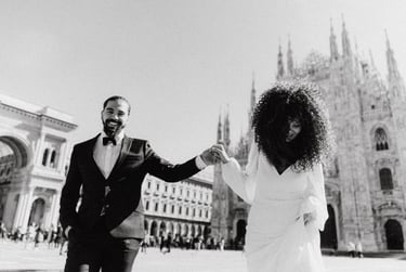 a man and woman holding hands and walking through in Milan Piazza Duomo
