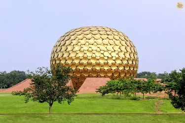 View of Matrimandir surrounded by green lawns in Auroville.