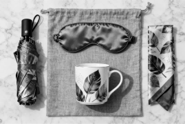 An elegant GWP lifestyle set including a compact umbrella, silk eye mask, and mug.
