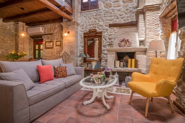 Spacious seating area in front of TV and fireplace with vintage style decor in Villa Galanoussa
