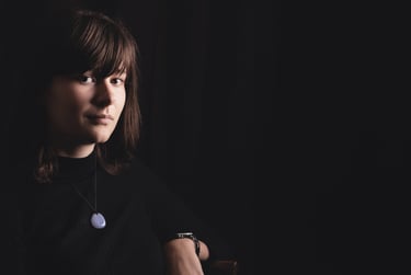 a woman in a black shirt and a necklace with a blue necklace