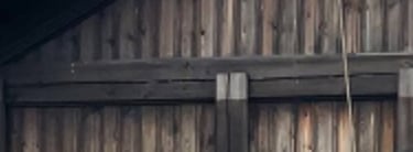 A wooden building, stabbur, with hills in the background-Telelaget