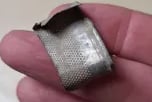flattened antique silver thimble.