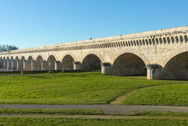 a bridge spanning a river with a bridge in the background
