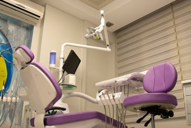 Modern dental clinic room with a purple examination chair and professional equipment.