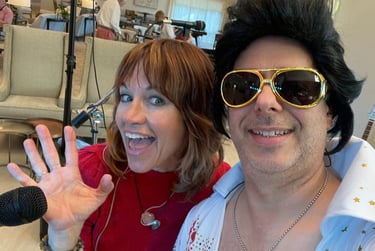 Tracy and Elvis in costume posing for a selfie at a social event.