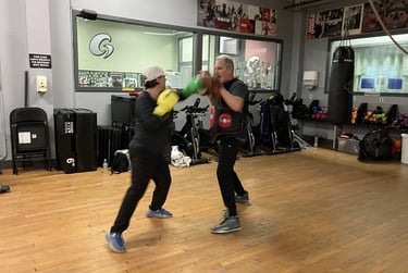 boxing instructor joe mccuttcheon with boxing participant