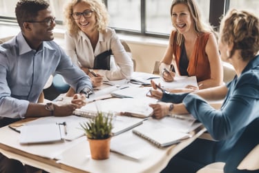three men laughing while looking in the laptop inside room