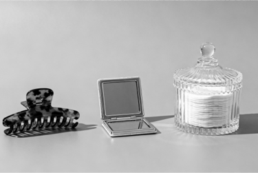 A minimalist set of daily essentials: hair clips, pocket mirror, and cotton pads.