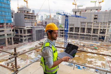 a man overlooking a construction site with a laptop