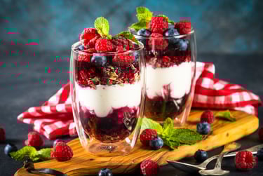 two glasses of yogurt with berries and mint leaves