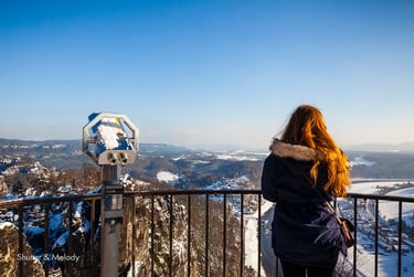 Eine Frau mit roten Haaren blickt auf die Böhmische Schweiz.