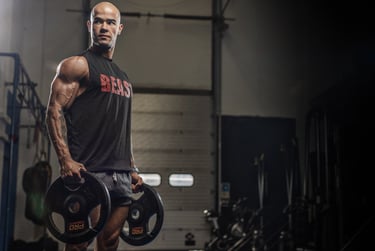 Coach Anderson, East London personal trainer, holding two weight plates.