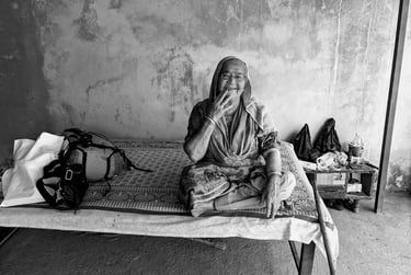 Photograph of a woman sitting on a bed