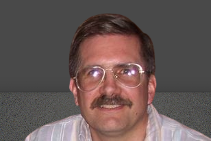 Elder Scott wearing glasses on a gray background