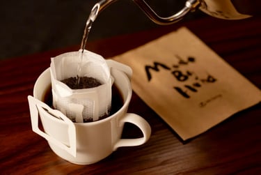 ドリップバッグに湯を注いでいる様子と横に置かれた「Made By Hand」パッケージ｜堺市のニュースならサカイタイムズ