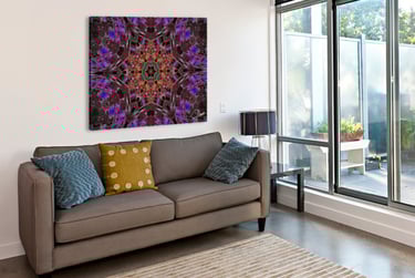 Canvas with abstract kaleidoscope design on wall above a couch beside a window. 