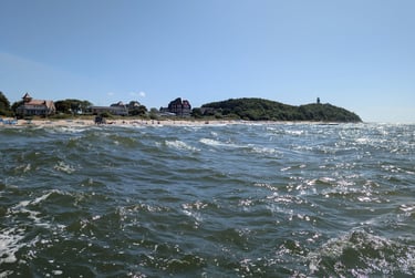 Choppy Baltic Sea waves crashing near the Hel Peninsula coastline on a sunny day