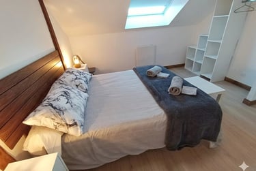 Chambre parentale lumineuse avec dressing et rangements au Gîte Bricabroc, idéal pour longs séjours 