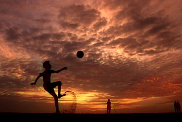 a person jumping up in the air with a ball