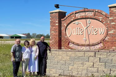 Pastors Brian and Alexis accompanied by Pastors Paul and Jan Juss at the entrance sign of Valleyview