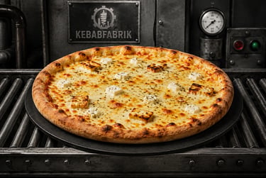 Freshly baked cheese pizza with feta and halloumi cubes on an industrial Kebabfabrik conveyor belt.