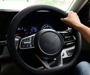 a hand is holding steering wheel