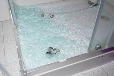 Shattered shower glass on a shower base showing need for urgent shower glass replacement in Auckland
